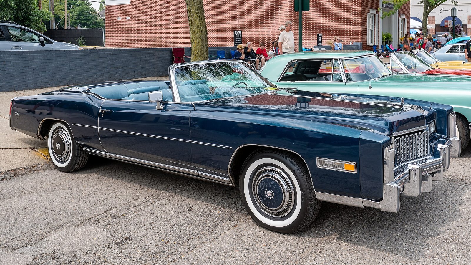 Deep blue 1976 Cadillac Eldorado convertible with full chrome trim and whitewall tires at a show